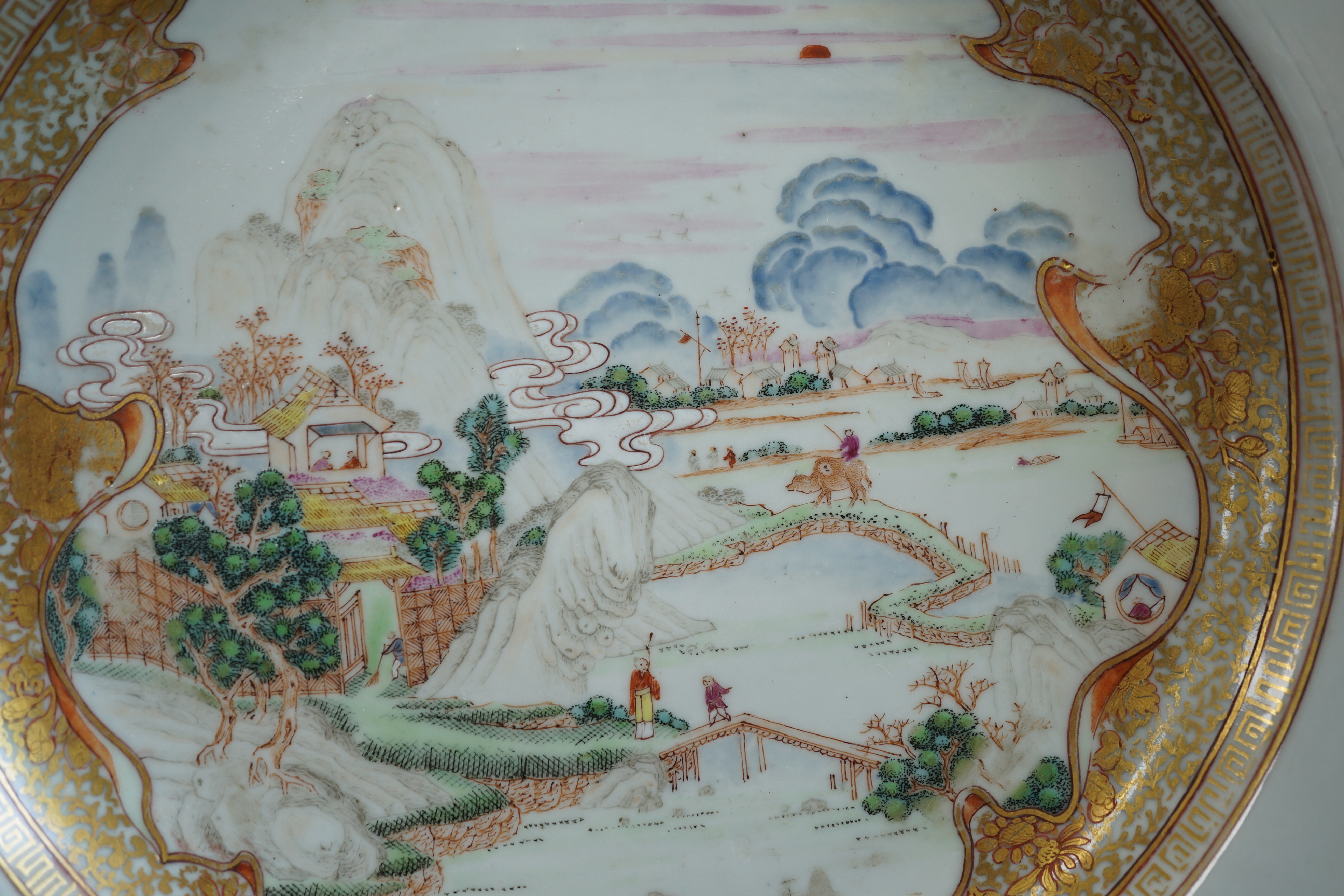 A pair of Chinese famille rose ‘landscape’ plates, Yongzheng-Qianlong period, small edge chip